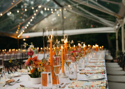 clear top tent with greenery twinkle lighting and paper lanterns