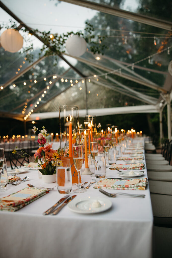 clear top tent with greenery twinkle lighting and paper lanterns