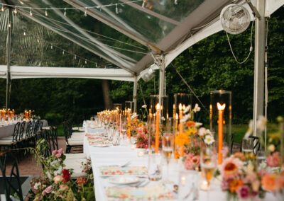 clear top wedding tent over table with flowers and orange candles