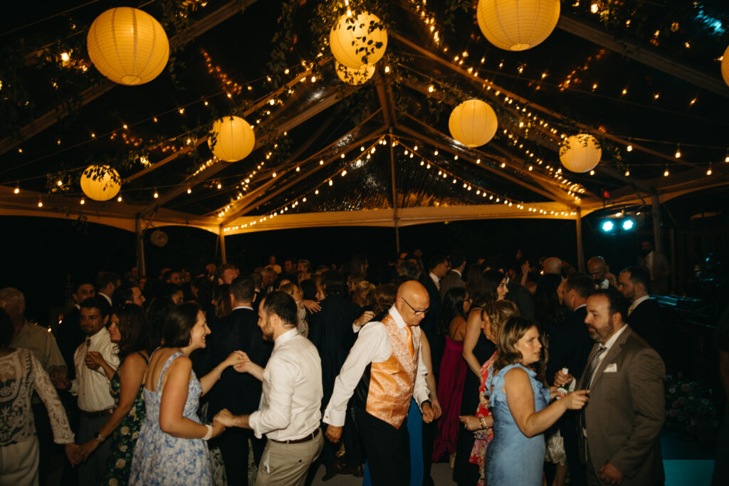 people dancing under glowing lighting at wedding reception