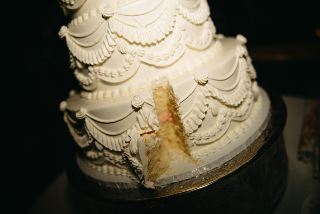 wedding cake with slice cut out of it