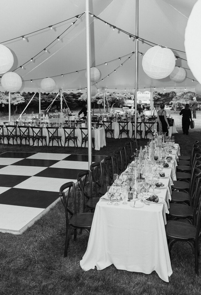 black and white photo of wedding reception under high peak pole tent