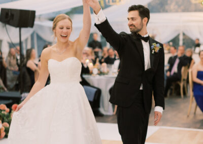 bride and groom dancing on birch and white check dance floor under clear wedding tent