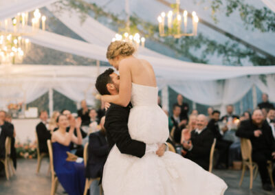 bride and groom dancing on birch and white check dance floor under clear wedding tent