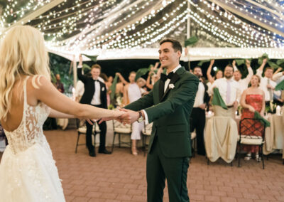 bride and groom dancing under clear top tent with twinkle lighting
