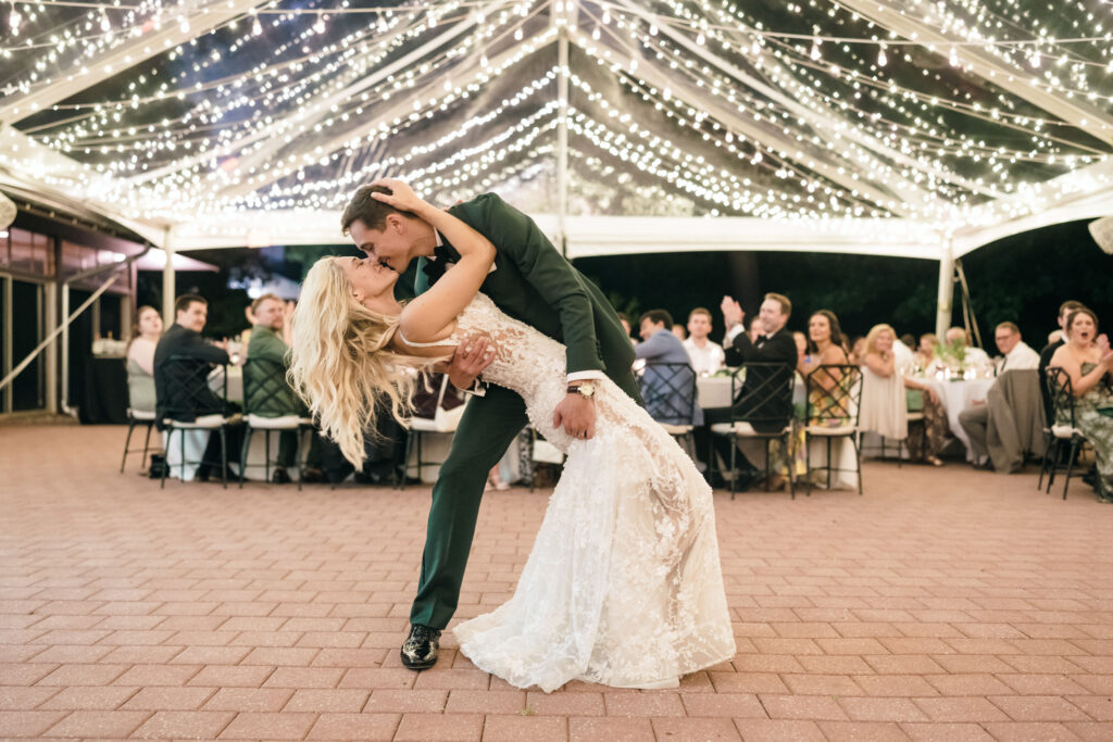 bride and groom dancing under clear top tent with twinkle lighting