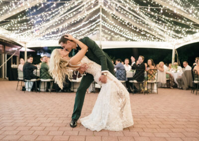 bride and groom dancing under clear top tent with twinkle lighting