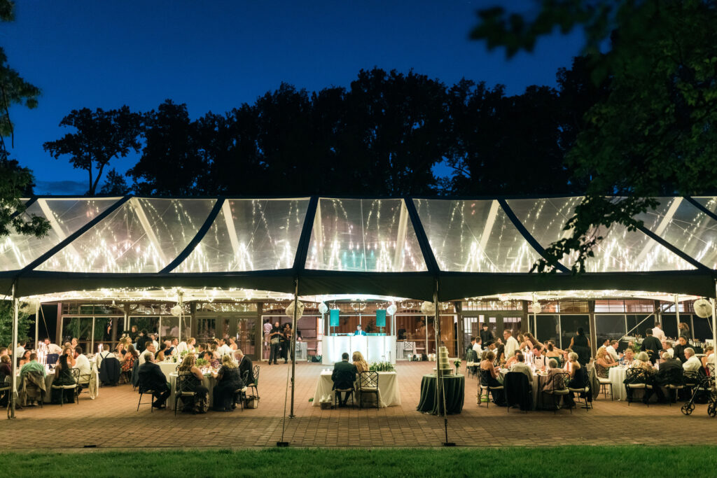 clear top wedding tent photo with twinkle lights glowing thru the tent top