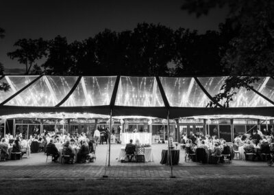 black and white photo of clear top wedding tent photo with twinkle lights glowing thru the tent top