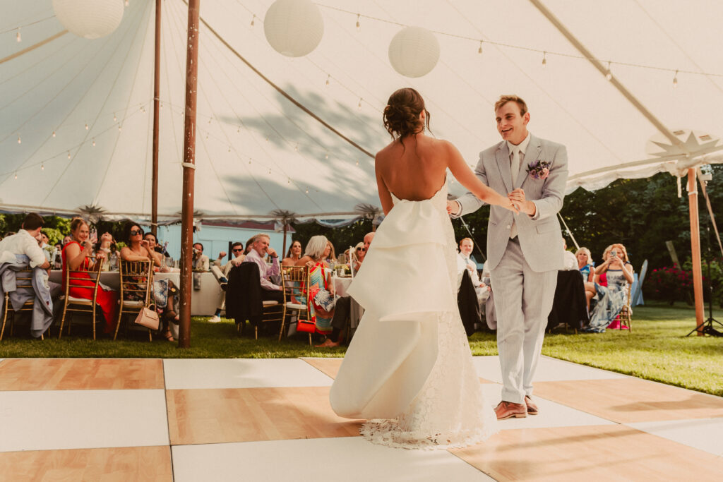 bride and groom dancing under wedding tent on birch and white check dance floor
